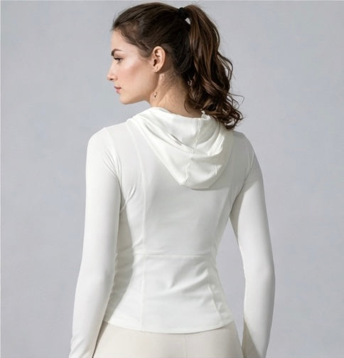 Woman wearing a white long-sleeve top against a gray background