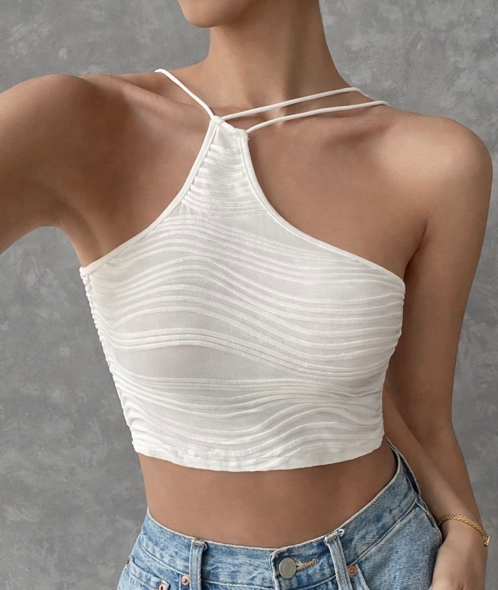 White crop top worn by a person against a gray background