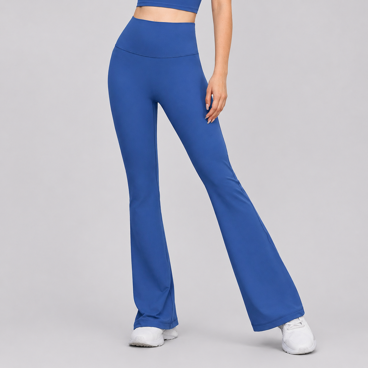 Blue flared pants worn by a person on a gray background
