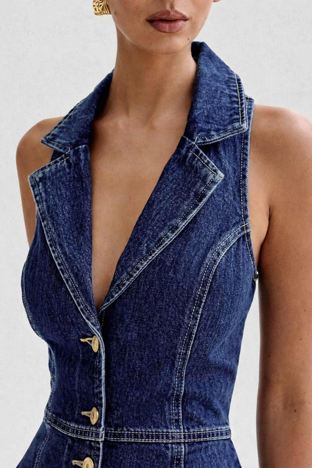 Denim vest worn by a model on a white background