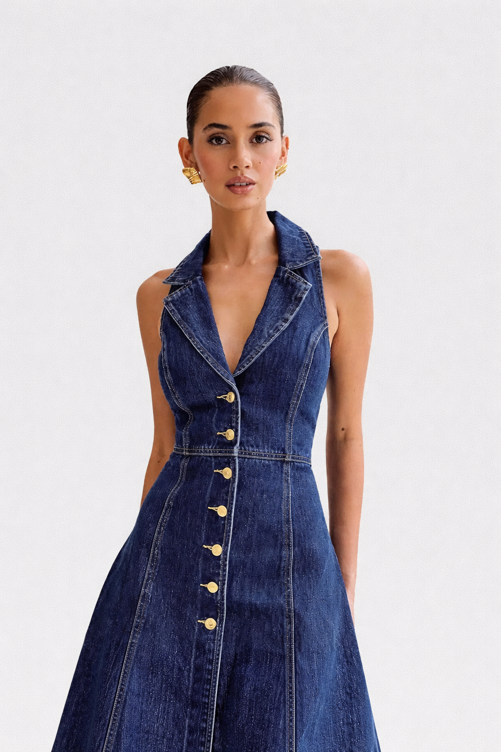 Woman wearing a denim dress with a white background