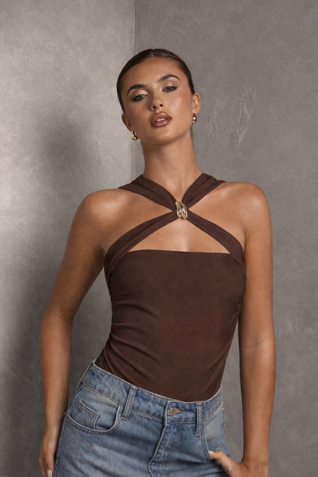 "Woman wearing a brown halter top and blue jeans...
