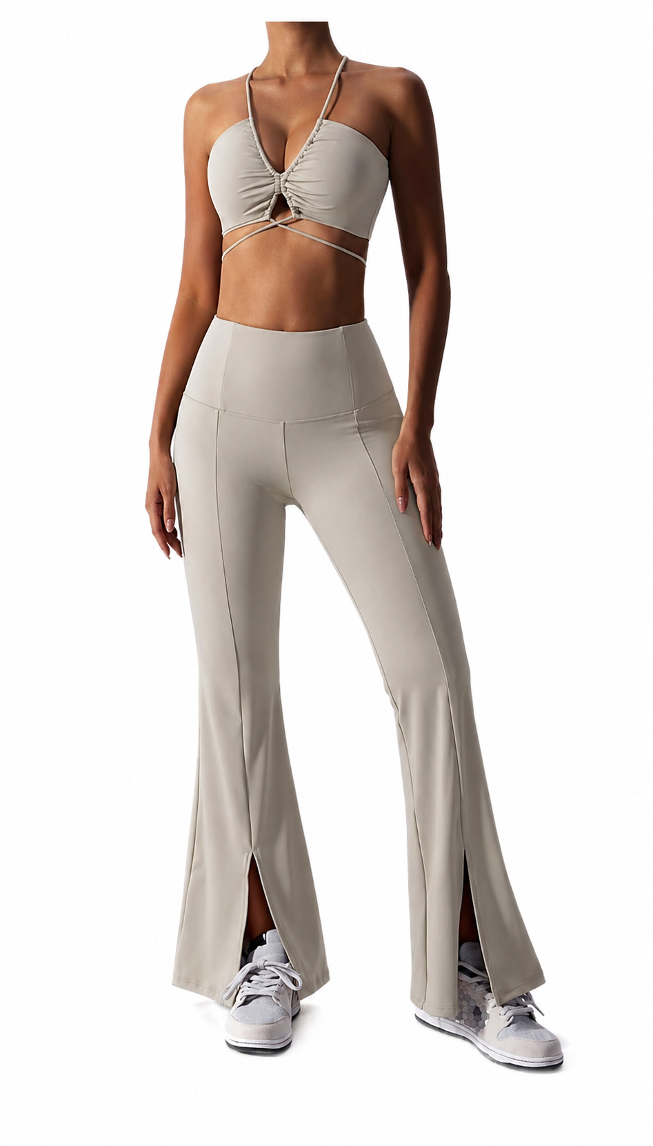 Woman wearing a beige sports bra and wide-leg pants on a white background