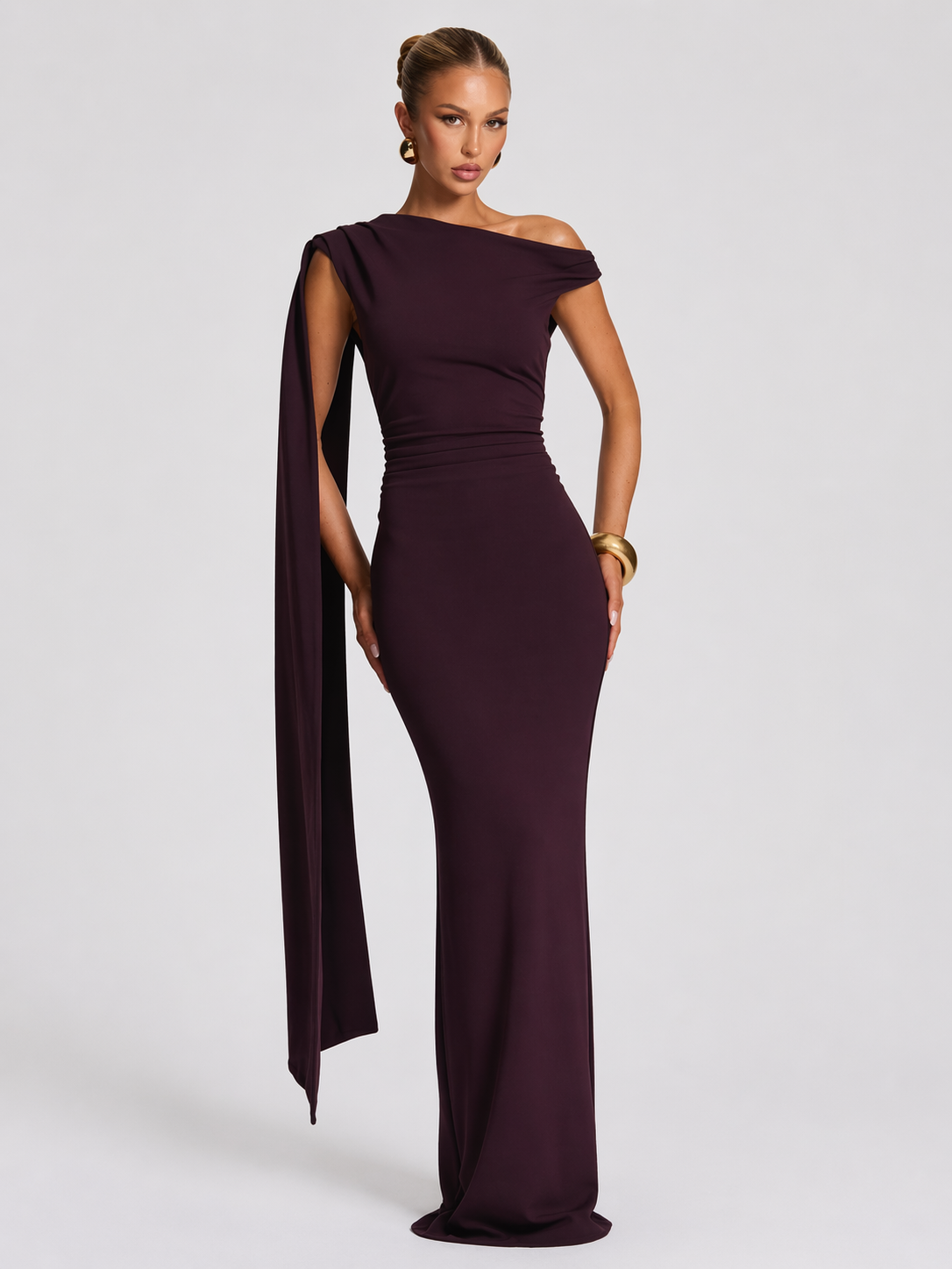 Woman wearing a burgundy off-shoulder gown on a white background
