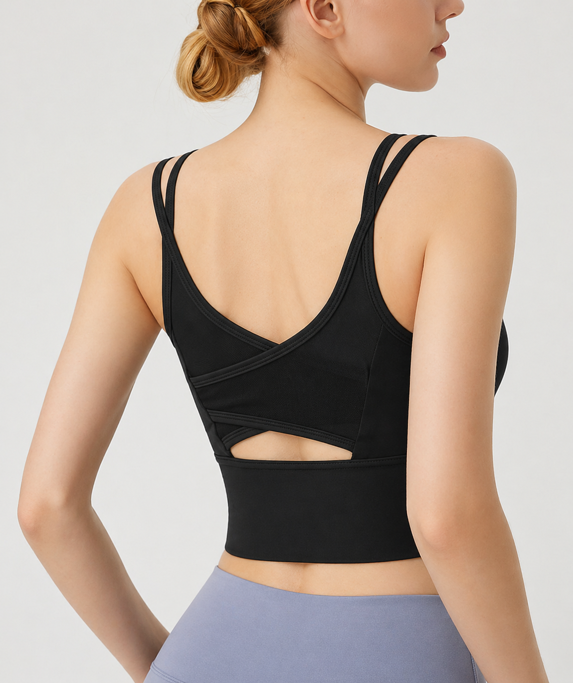 Black sports bra with cut-out design on a plain background