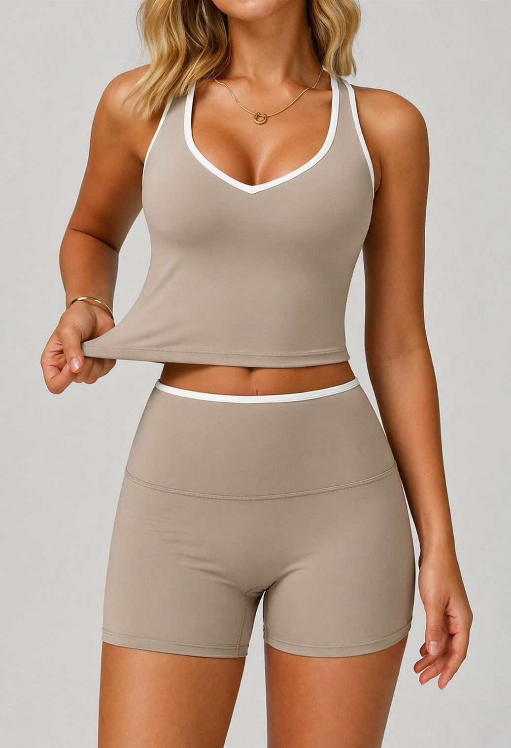 Woman wearing a beige tank top and shorts set on a plain background