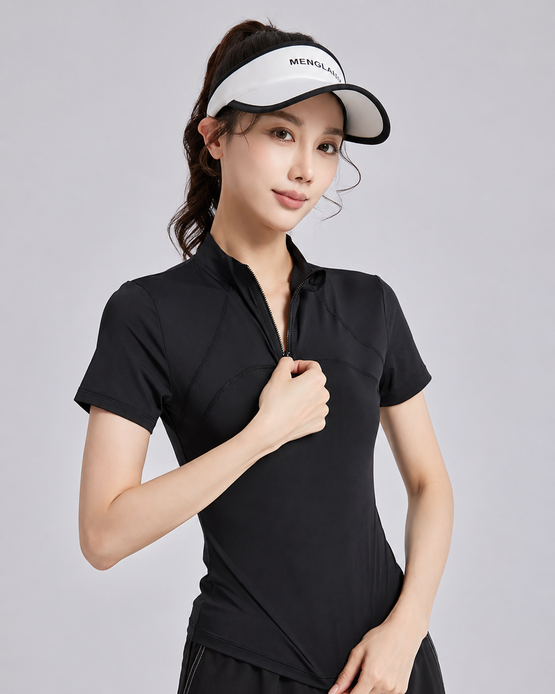 Woman wearing a black athletic outfit with a white visor on a gray background