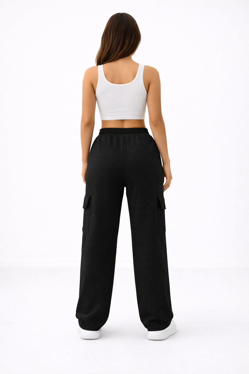 Person wearing a white crop top and black wide-leg pants on a white background