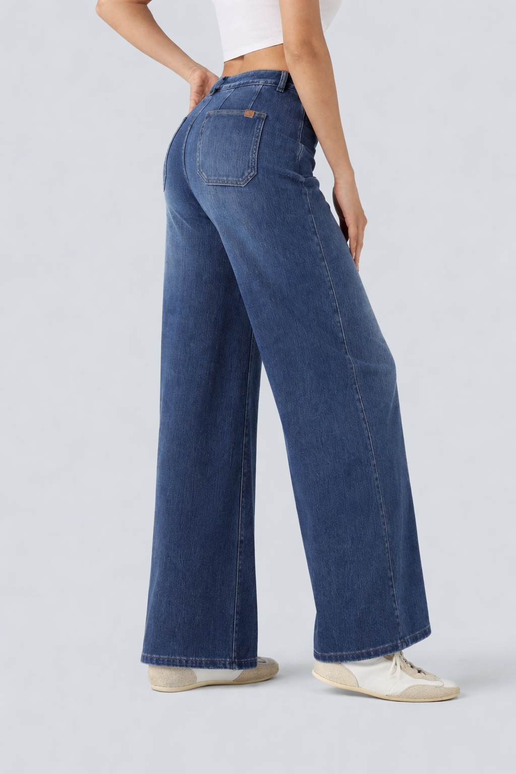 Person wearing blue wide-leg jeans on a light gray background