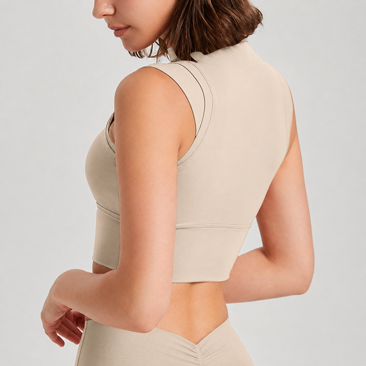Beige sleeveless top worn by a person on a light gray background