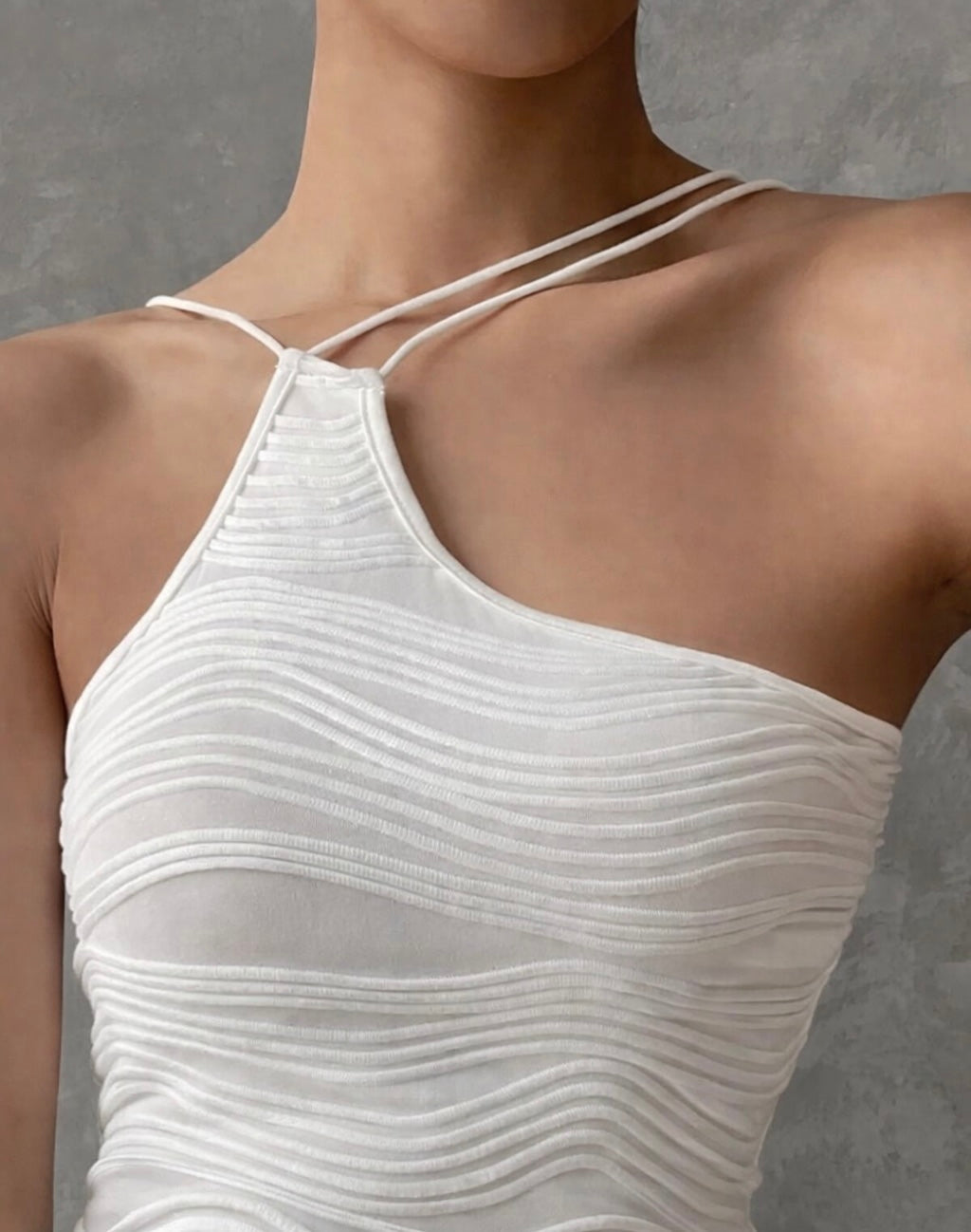 White halter top worn by a model against a gray background