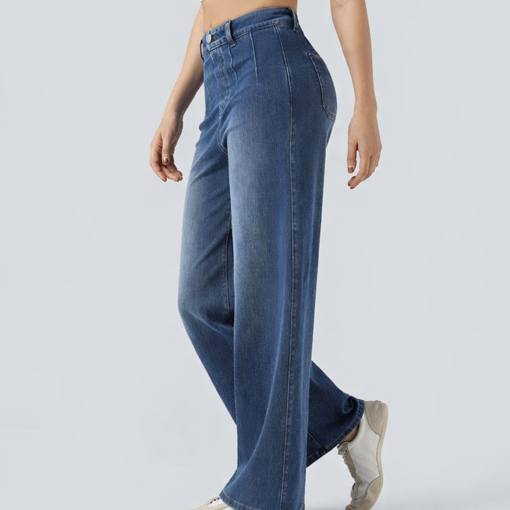 Person wearing blue jeans on a plain background