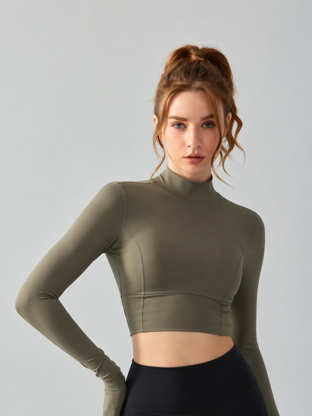Woman wearing a green long-sleeve crop top against a gray background