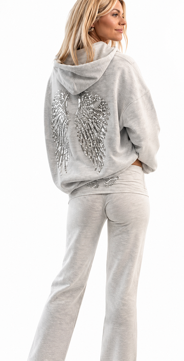 Woman wearing a gray hoodie with decorative elements and matching pants on a white background