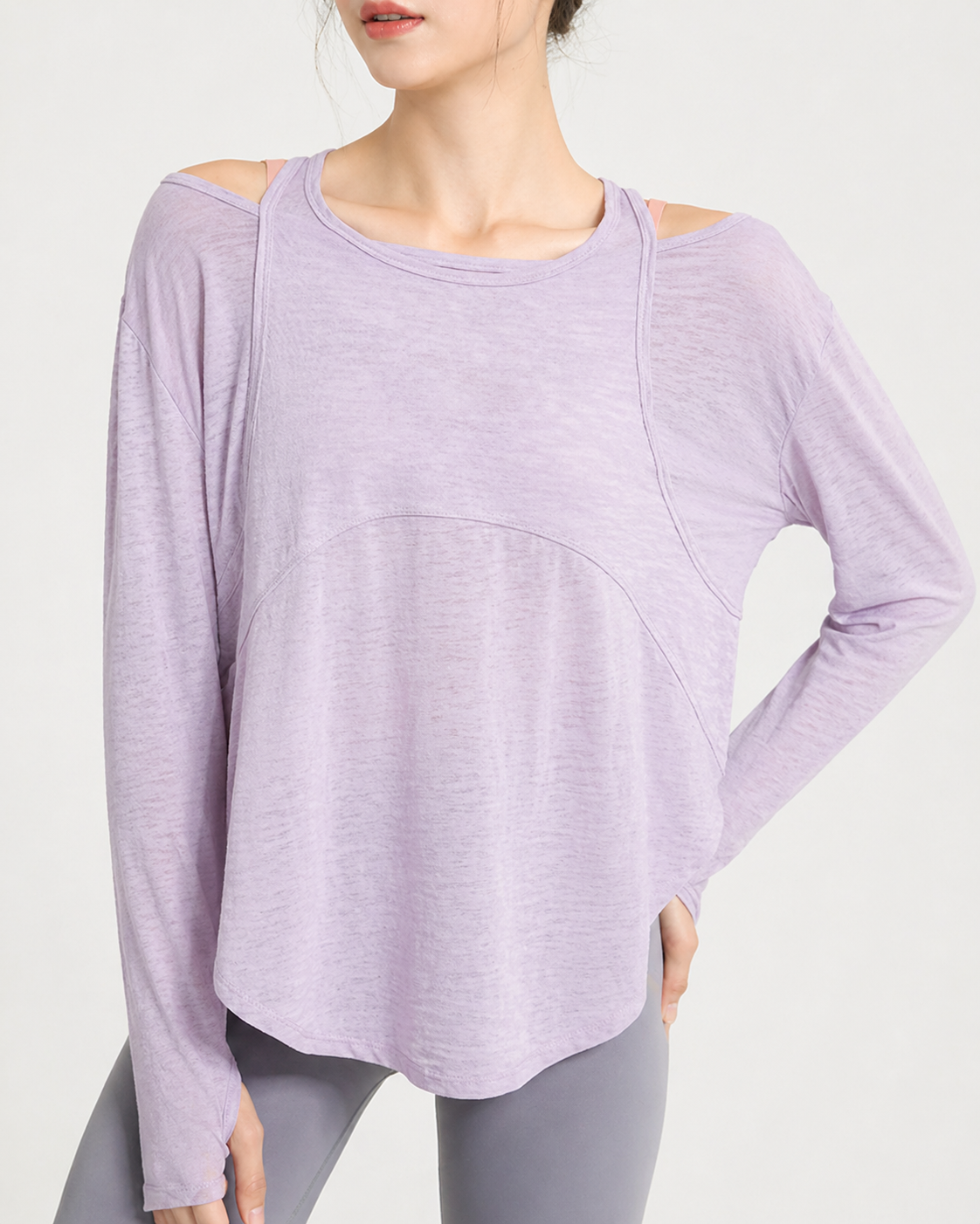Person wearing a light purple long-sleeve top with cut-out shoulders on a white background