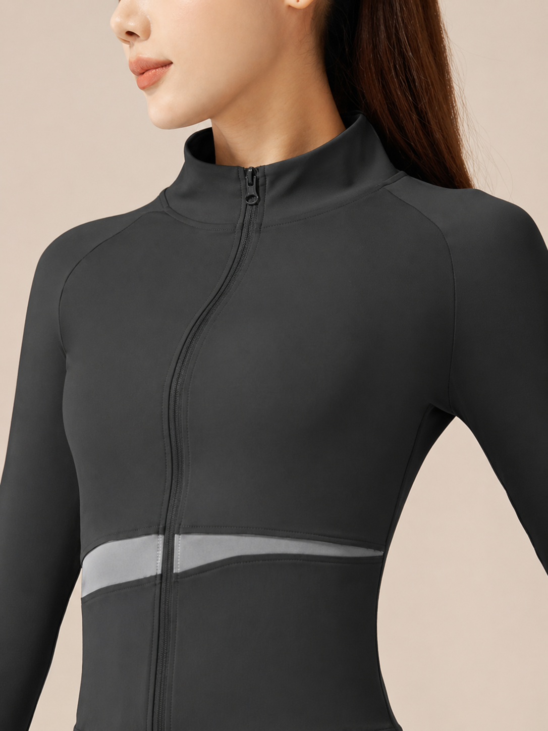 Black athletic jacket with mesh panels on a beige background