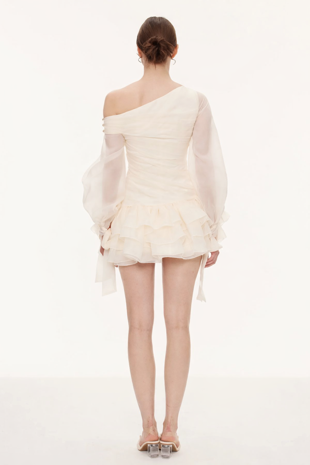 White one-shoulder dress worn by a model on a white background