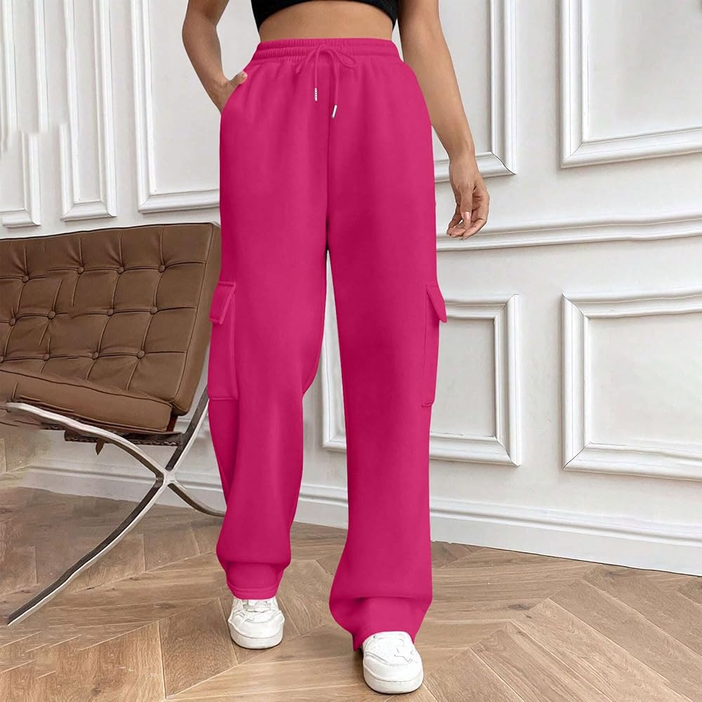 Person wearing bright pink cargo pants in a room with a brown chair and white walls.
