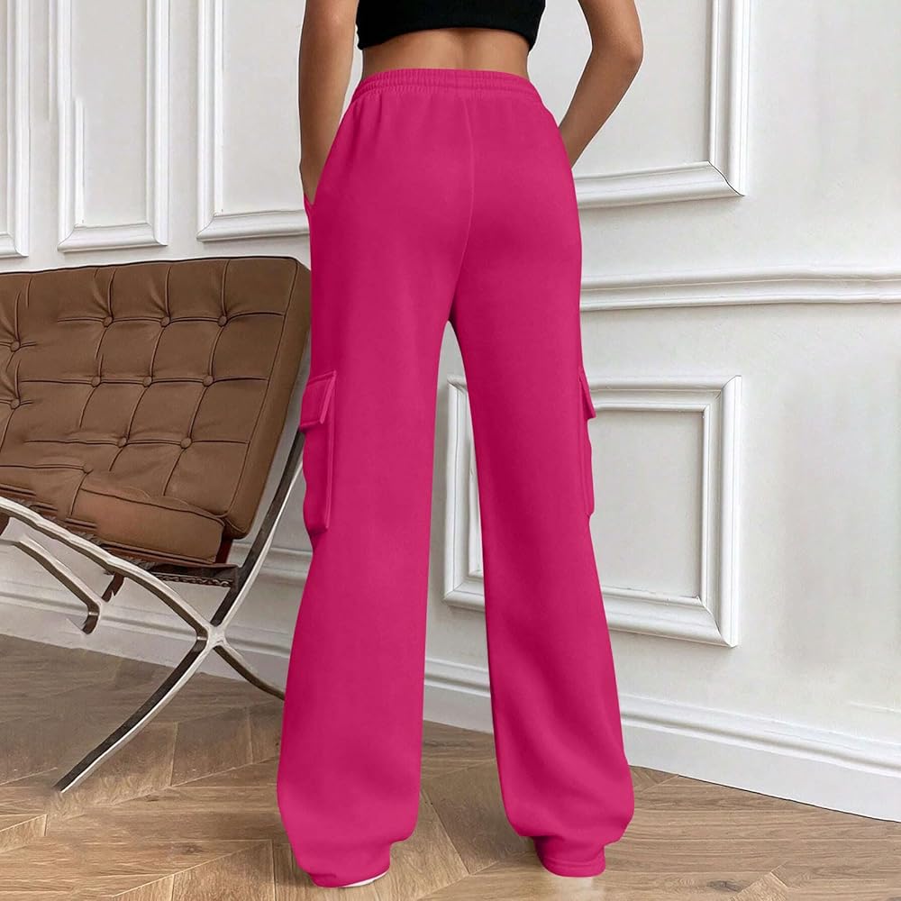 Person wearing bright pink cargo pants in a room with a brown chair and white walls.