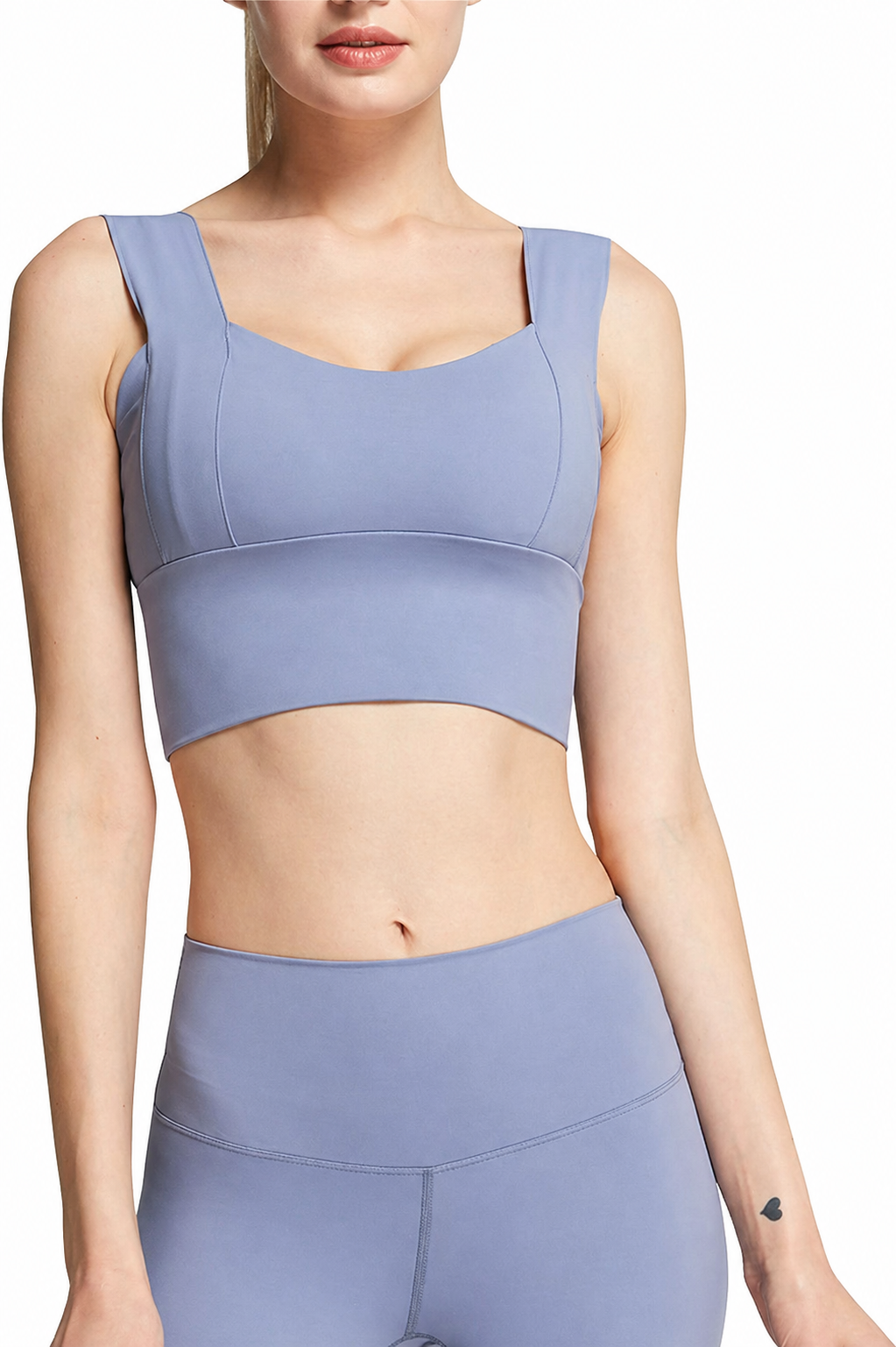 Person wearing a light blue sports bra and leggings set on a white background