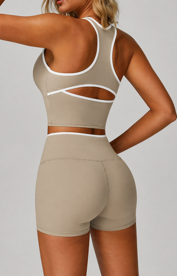Person wearing a beige sports bra and shorts set on a plain background