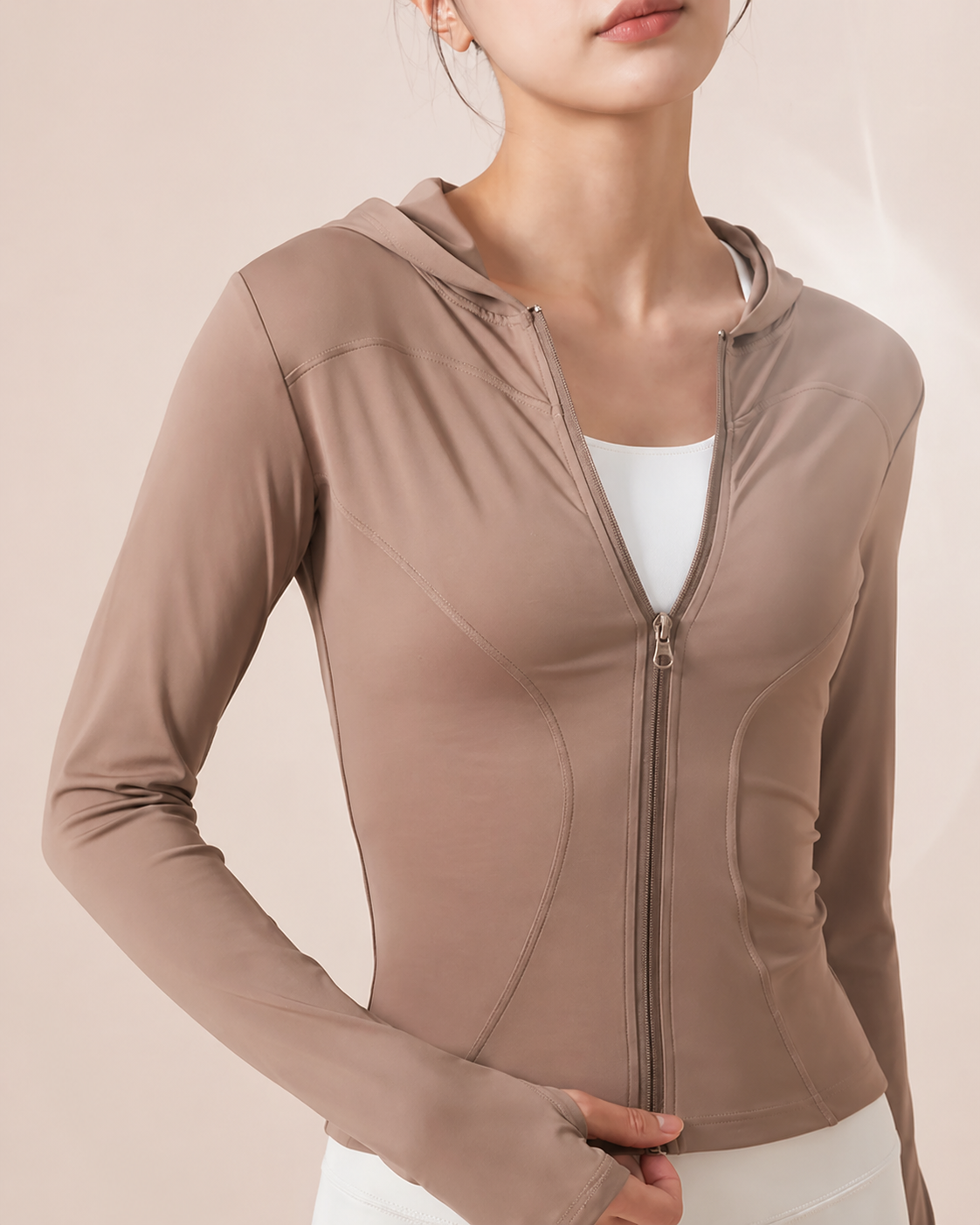 Brown zip-up hoodie worn by a person on a beige background