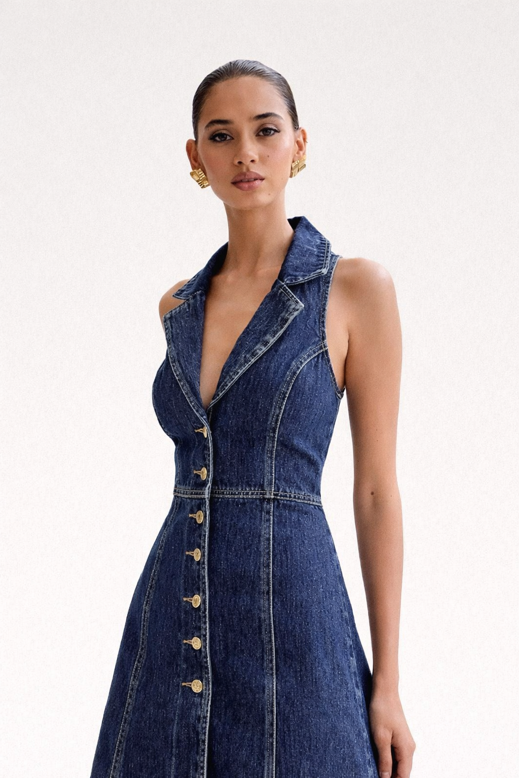 Woman wearing a denim dress with a white background