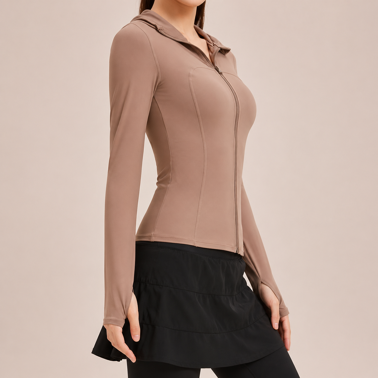 Woman wearing a brown long-sleeve top with a zipper on a beige background
