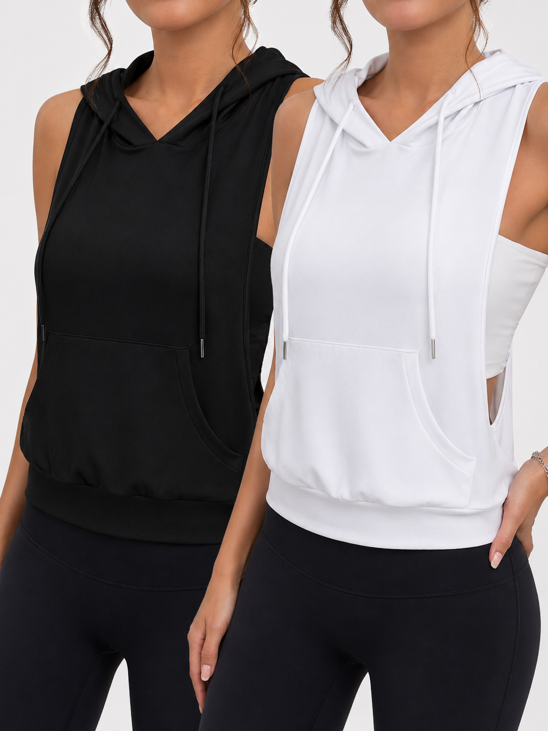 Two women wearing black and white sleeveless hoodies on a plain background