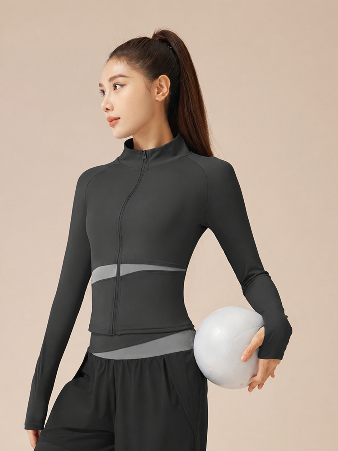 Woman wearing a black athletic outfit holding a white ball on a beige background