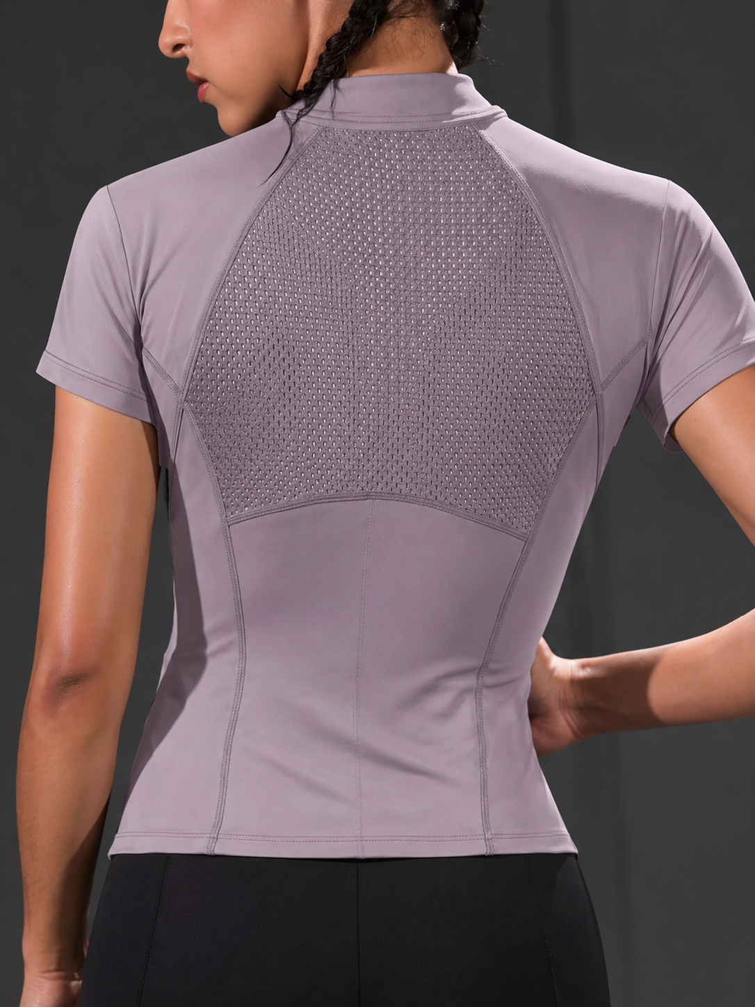 Light purple athletic shirt with mesh back on a person against a dark background