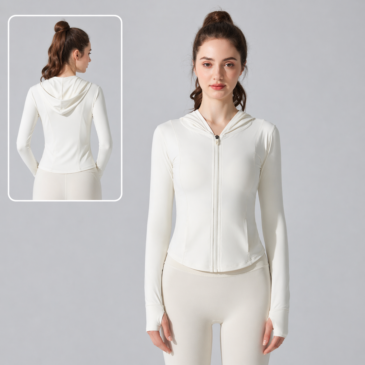Woman wearing a white hoodie and leggings on a gray background