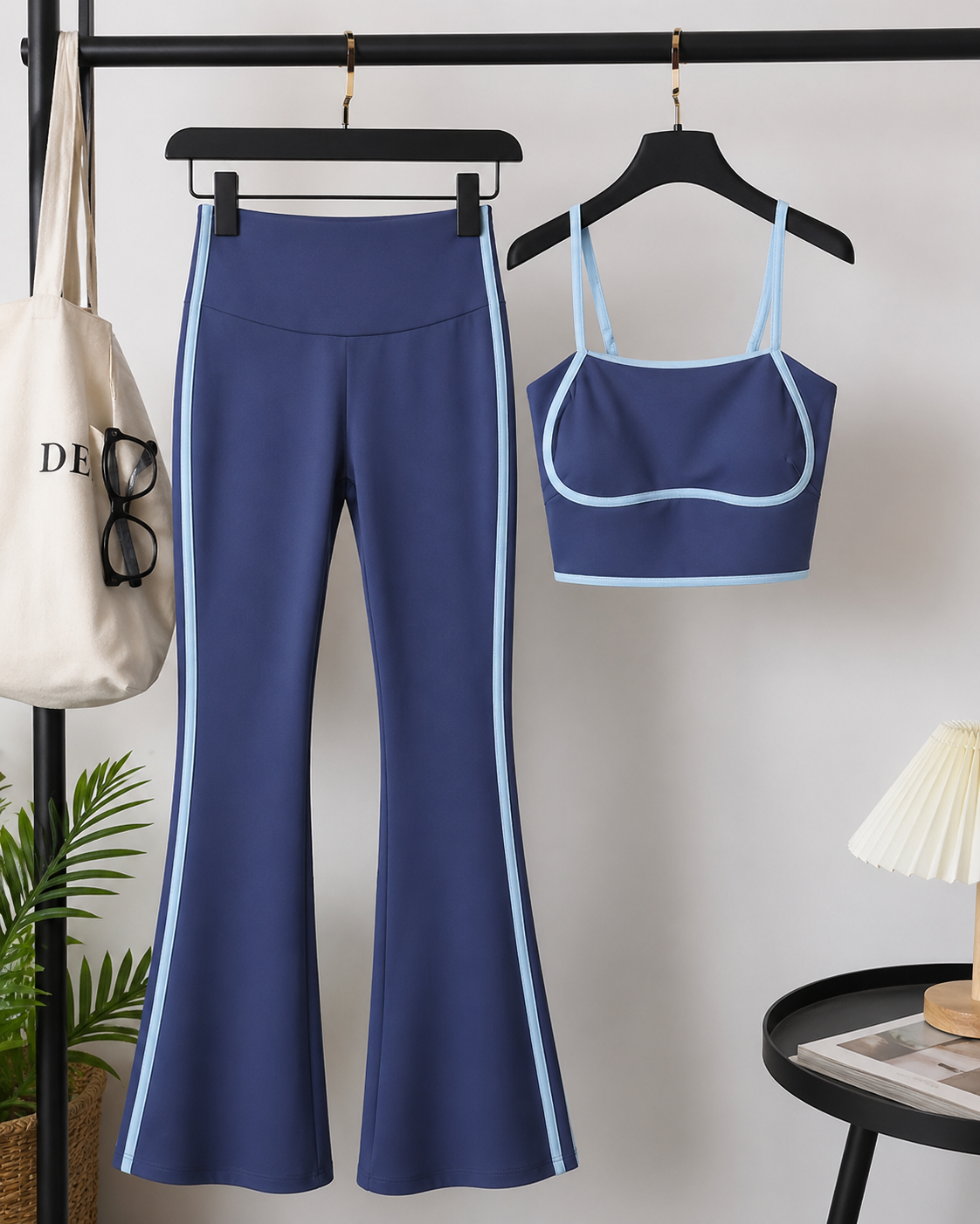 Blue athletic outfit with pants and crop top on hangers against a neutral background.