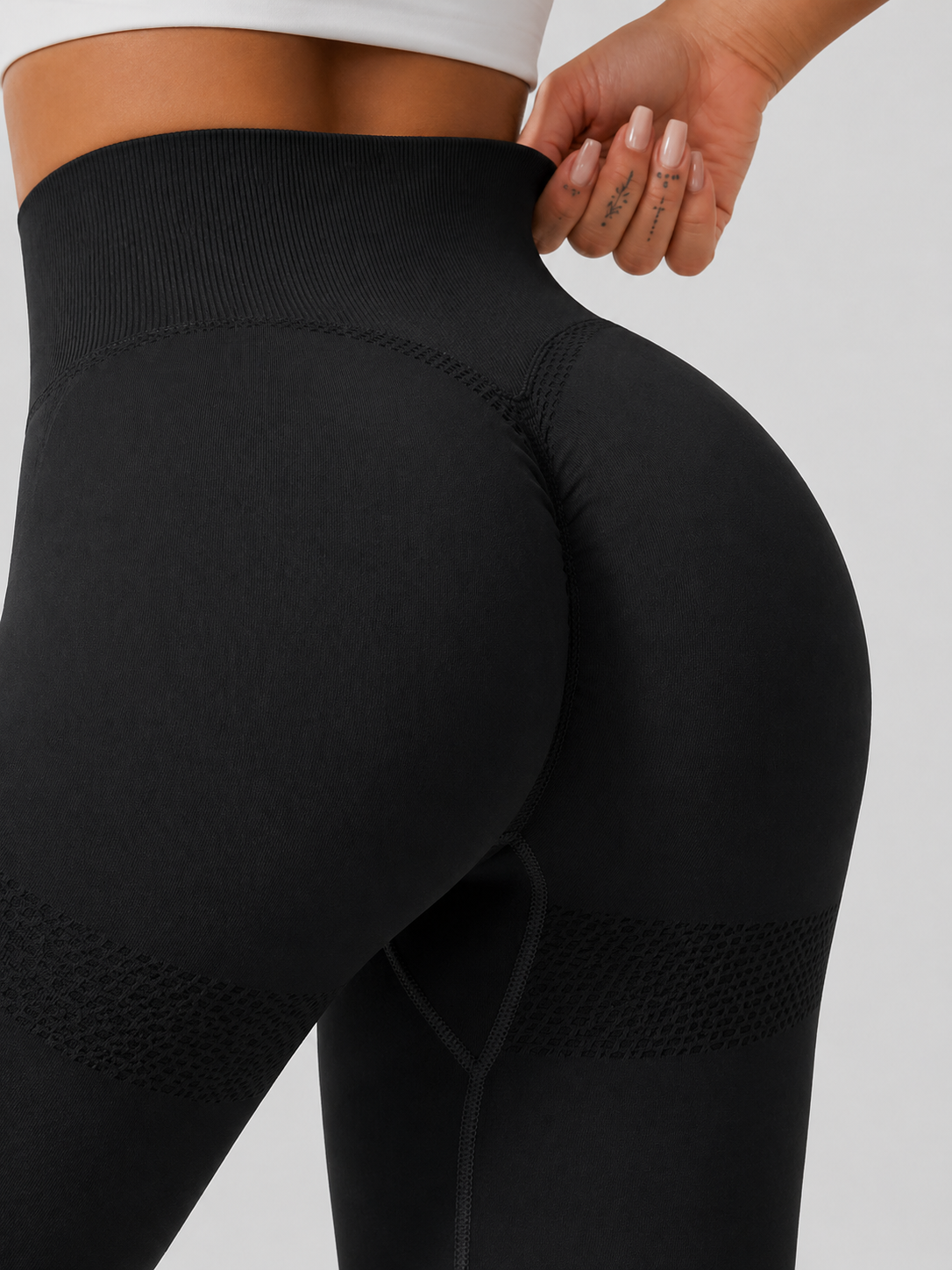 Black leggings worn by a person on a light gray background