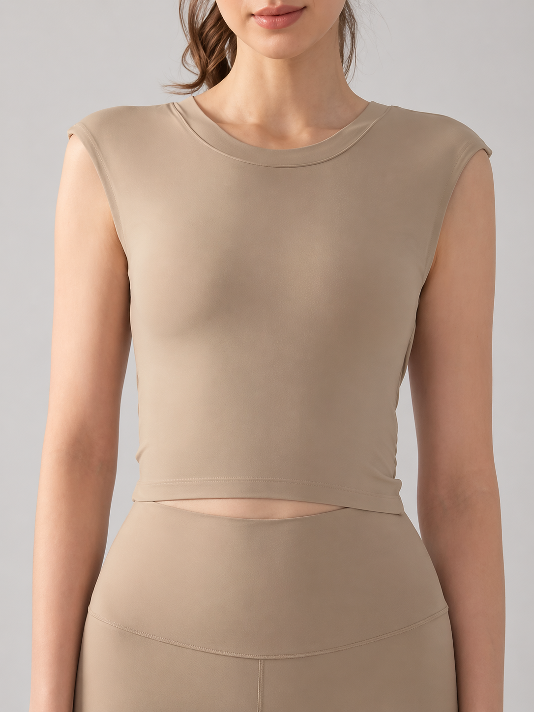 Beige sleeveless top worn by a person on a plain background