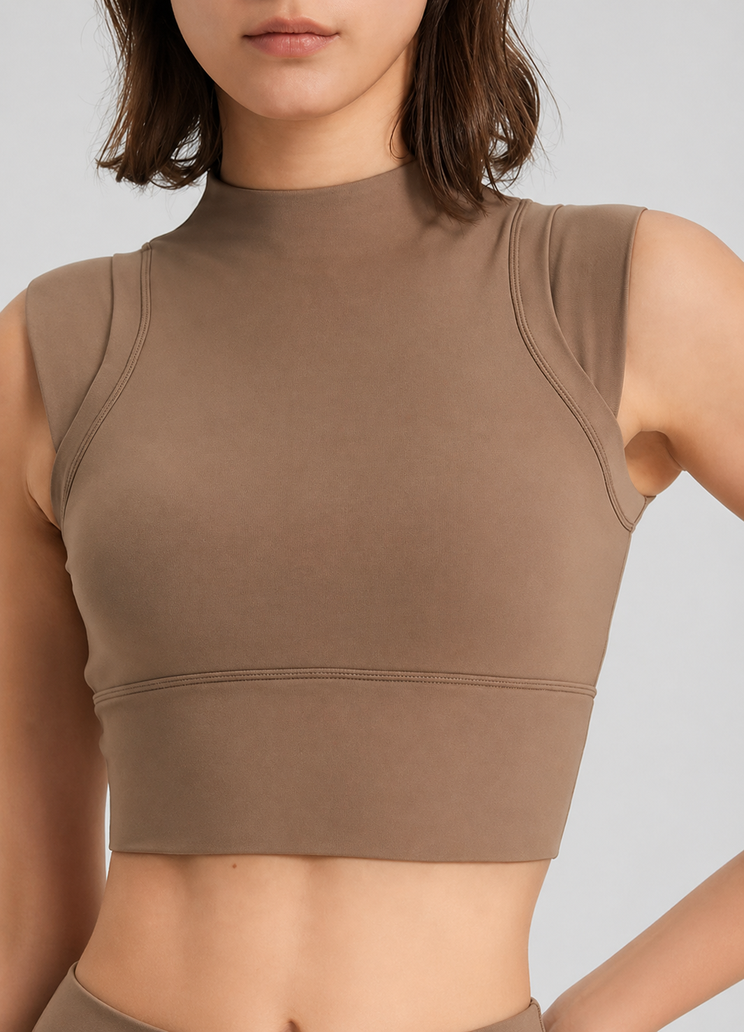 Brown sleeveless top worn by a person on a light gray background