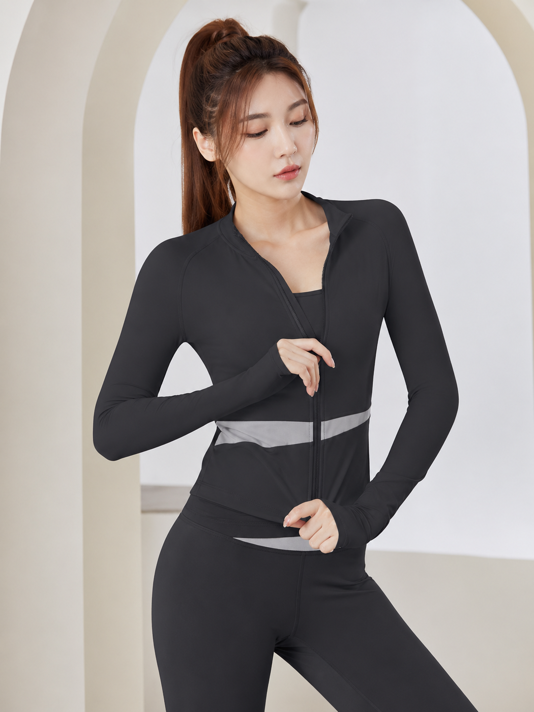 Woman wearing a black athletic outfit with a white background