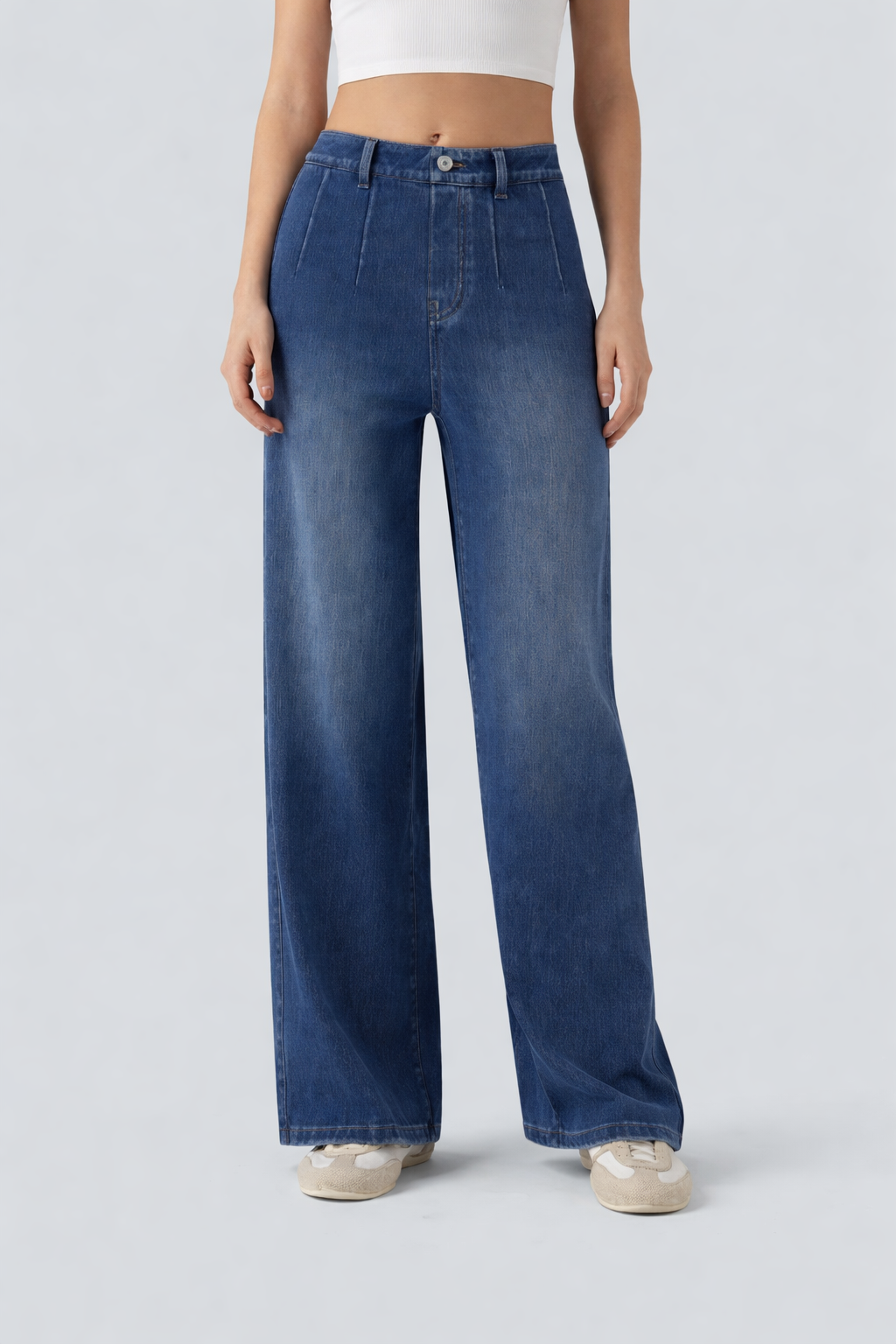 Person wearing blue wide-leg jeans on a light gray background