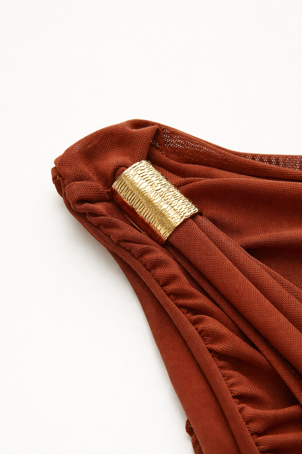 Brown fabric with a gold metal ring on a white background