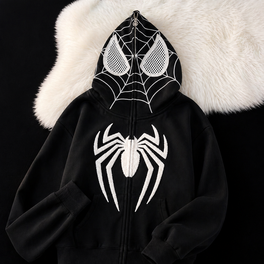 Black hoodie with white spider design on a textured white surface