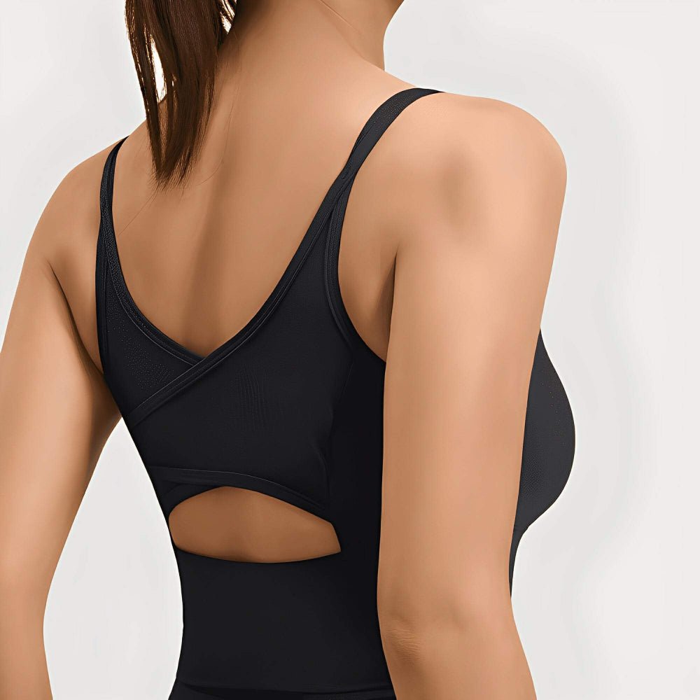 Black sports bra worn by a person on a plain background