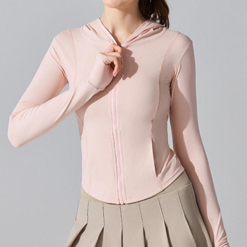 Person wearing a light pink zip-up hoodie against a gray background