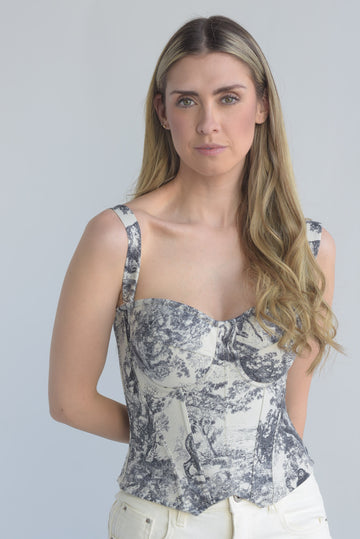 Woman wearing a patterned top against a plain background
