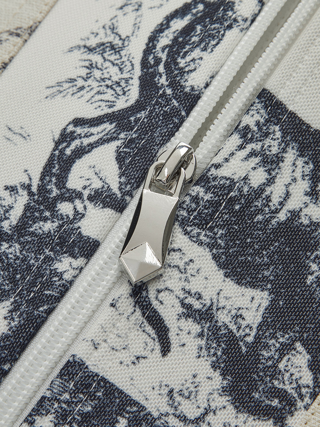 Close-up of a zipper on a fabric with black and white pattern