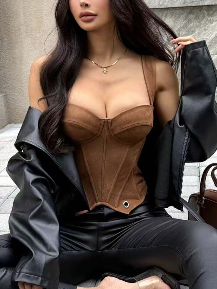 Person wearing a brown leather corset and black jacket outdoors.