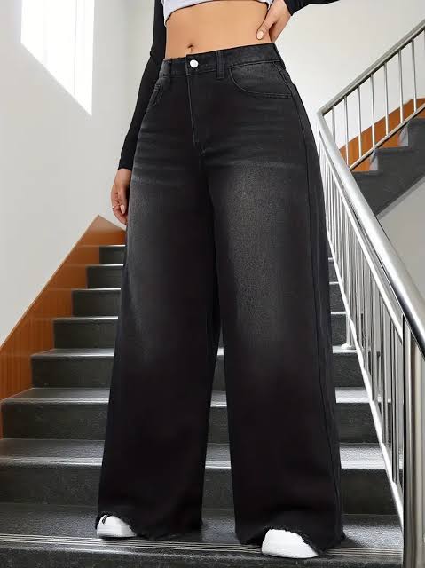 Person wearing black wide-leg jeans standing on a staircase.