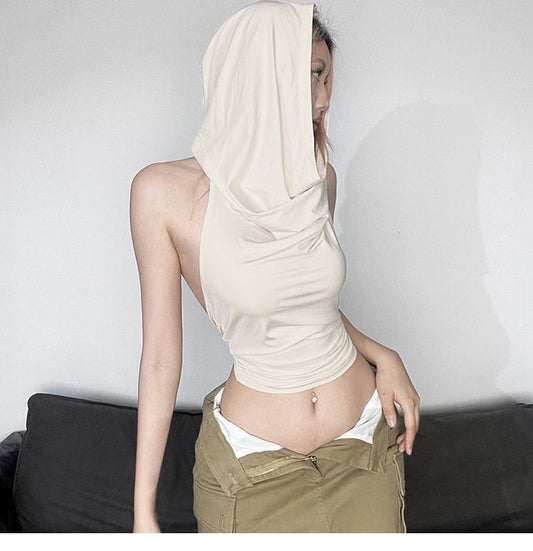Person wearing a beige top and khaki pants with a white sheet draped over their head.